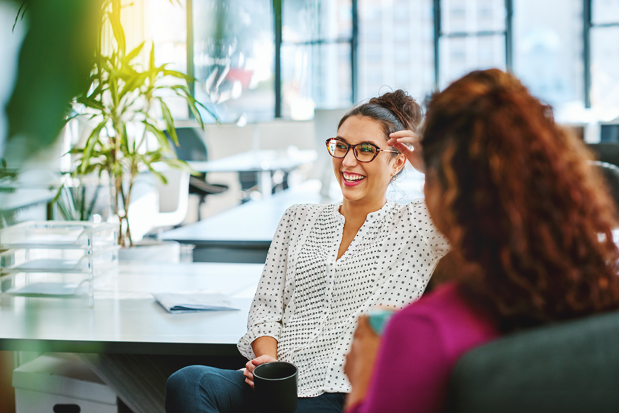 Two women sharing a laugh in an office