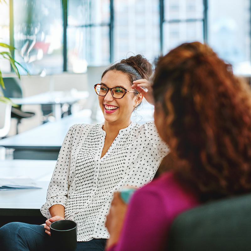 Two women sharing a laugh in an office