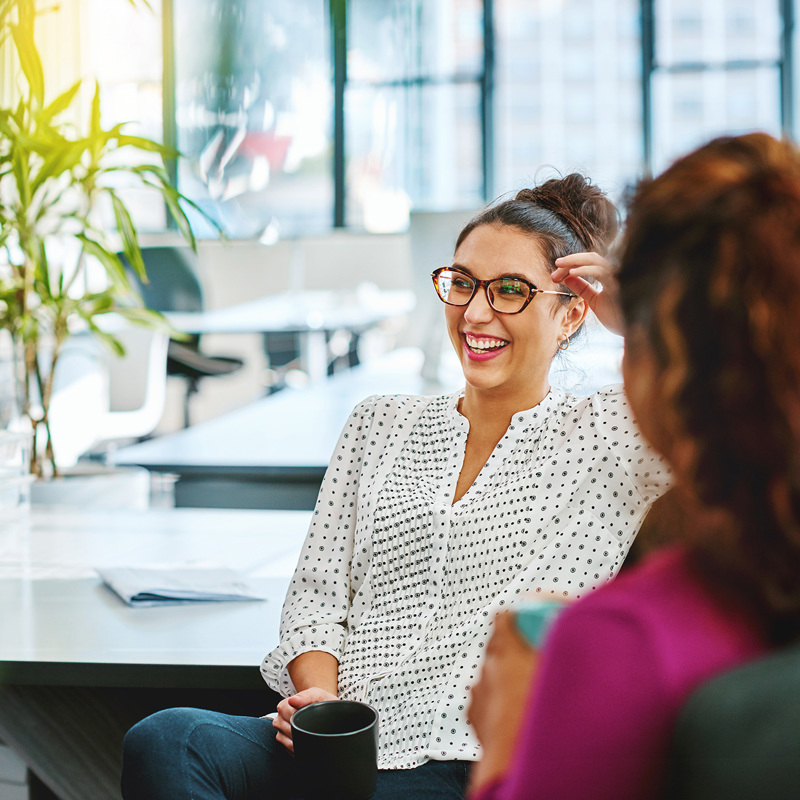 Two women sharing a laugh in an office