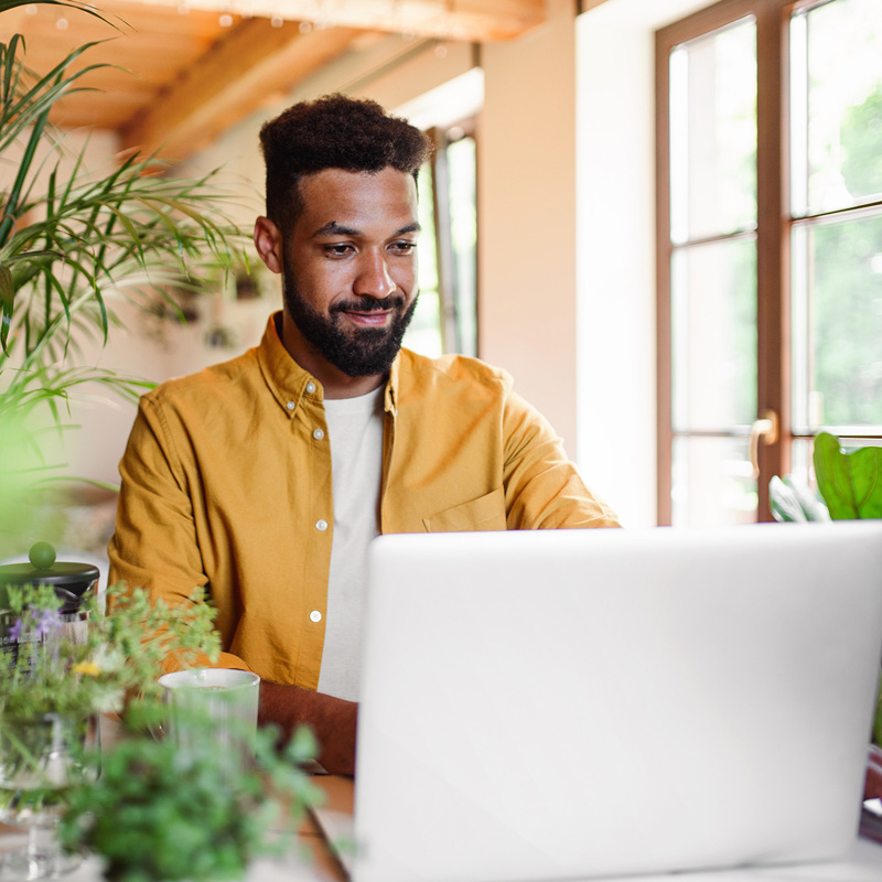 Young man working surrounded by plants 